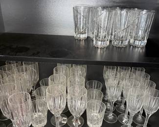 Cut Glass Stemware and Highball Glass Lot A large lot of clear cut glass stemware, including water goblets, wine glasses and flutes, plus a set of highball glasses with diagonal cuts. Some pieces still have their stickers. Enough glassware to set a full table for entertaining.