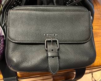 Coach New York Black Pebbled Crossbody Bag A Coach New York black pebbled-texture crossbody bag with a front flap, a buckle strap closure, contrast stitching and a gunmetal-tone logo. This designer crossbody purse is a versatile everyday bag. It looks to be in good condition in the photo.