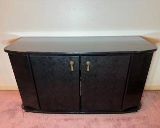 Black Two-Door Sideboard with Burl-Pattern Doors A black sideboard with two burl-pattern doors, brass-tone teardrop pulls, rounded ends and a glossy top. A modern buffet cabinet with closed storage for a dining room or entertainment wall. The finish looks clean in the photo.