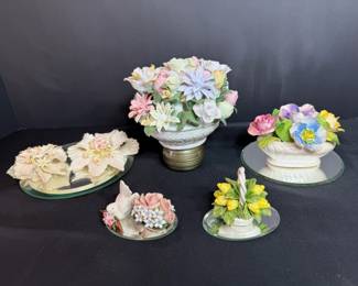 Ceramic Flower Bouquets on Mirror Plateaus A lot of sculpted ceramic flower arrangements, including a large mixed bouquet on a pedestal base, white poinsettias, a dove with roses and a basket of yellow flowers, several set on round mirror plateaus. Colorful decor for a vanity, curio or tabletop. Check the petals closely in person.