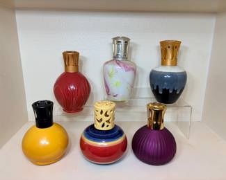 Decorative Fragrance Lamps – Set of Six Six decorative fragrance lamps with metal crown tops, in red, yellow, purple, swirl glass, drip glaze and striped designs. Colorful home fragrance accent pieces. No brand is visible in the photo.