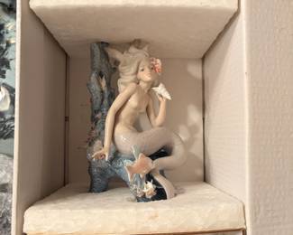Mermaid Figurine in Foam-Lined Box A mermaid on coral reef figurine shown nestled in a white foam-lined box. Packaging like this makes storing or shipping a fragile figurine much easier.