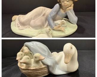 Lladró Porcelain Girl with Ducklings and Goose with Goslings Figurines Two Lladró porcelain figurines: a girl lying on a grassy base, resting her chin on her hand beside two ducklings, and a white goose with three goslings in a woven basket under a blue cloth. Charming Lladro farm animal figurines for a country decor collection.