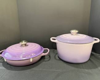 Purple Enameled Braiser and Le Creuset Lilac Round Dutch Oven A purple enameled braiser with a stainless knob, and a large lilac round Dutch oven with an embossed Le Creuset lid. Pastel enameled cookware for braising and slow cooking. Lid clips are still in place.