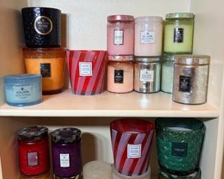 Voluspa Candle Collection – Two Shelves Two shelves of Voluspa candles in embossed glass, metallic and striped jars, including Crushed Candy Cane, Coconut Papaya, Burning Woods and Temple Moss. Many look unused. A large luxury candle lot that's ideal for gifting.