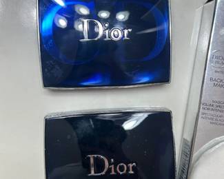 Dior Eyeshadow Compacts A close-up of two Dior eyeshadow compacts with the Dior logo on the lids, next to a Dior mascara box. Designer makeup in compact cases. Usage level not confirmed — inspect in person.