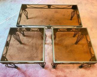 Set of Three Metal Frame Smoked Glass Tables Three metal-frame tables with smoked glass tops and decorative scroll and finial details, shown from above. Glass-top accent tables for a living room or patio. Confirm the dimensions in person.