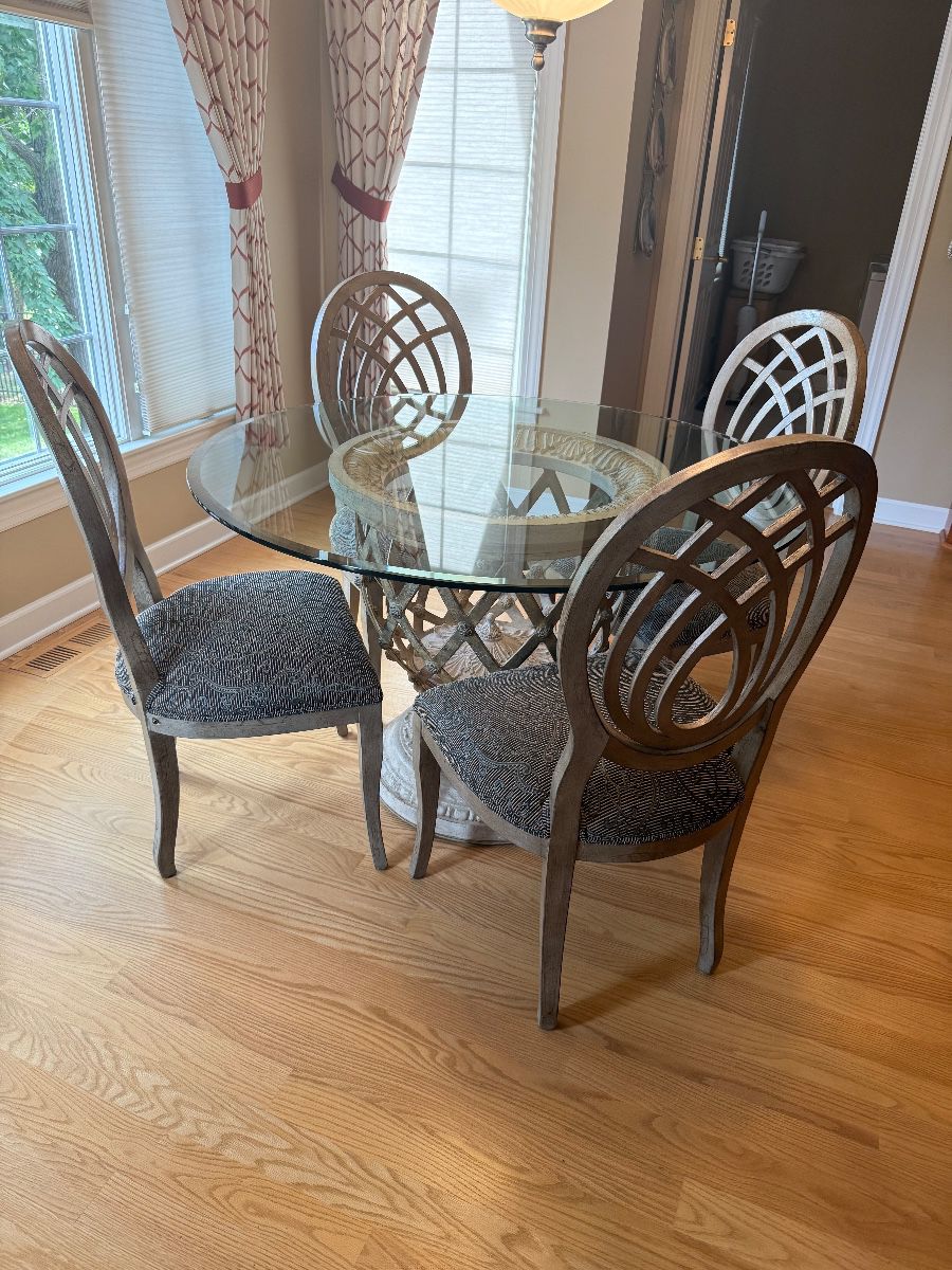 Round 48" glass-top dining table with a decorative pedestal base & 4 upholstered chairs $400
