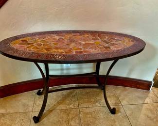 An oval Mosaic top with a decorative metal bottom