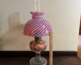 H44 - $85. Electric lamp with cranberry opalescent glass shade. Measures 24" tall.