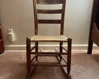 H18 - $30. Shaker Style Ladderback Rocking Chair. Measures 16.5" x 17" x 32"T, floor to seat 15.75"T. Some surface wear, but structurally sound.