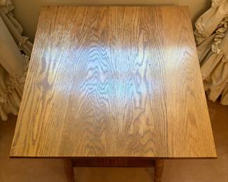 H25 - $50. Parlor Table with Bobbin Turned Spindle Legs. Measures 19.5" x 19.75" x 28.75"T. Trim piece is starting to separate from tabletop as shown in photo.