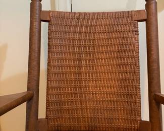 H29 - $40. Wood rocking chair with woven seat and back. Measures 26.25" x 24" x 35"T. Some separation of seat weaving as shown in photo.