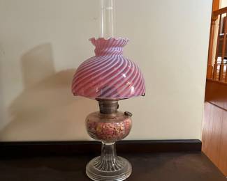 H44 - $85. Electric lamp with cranberry opalescent glass shade. Measures 24" tall.