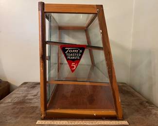 H50 - $450. Tom's toasted peanuts countertop display cabinet. Measures 24" x 12" x 16" tall. One top corner has cracked glass but it's still in the case.