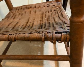 H29 - $40. Wood rocking chair with woven seat and back. Measures 26.25" x 24" x 35"T. Some separation of seat weaving as shown in photo.