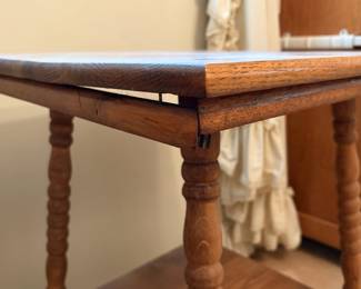 H25 - $50. Parlor Table with Bobbin Turned Spindle Legs. Measures 19.5" x 19.75" x 28.75"T. Trim piece is starting to separate from tabletop as shown in photo.