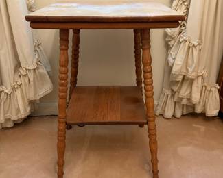 H25 - $50. Parlor Table with Bobbin Turned Spindle Legs. Measures 19.5" x 19.75" x 28.75"T. Trim piece is starting to separate from tabletop as shown in photo.