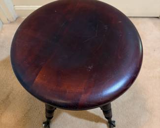 H31 - $75. Adjustable height carved piano stool. Measures 14.5" x 19"T.