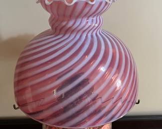 H44 - $85. Electric lamp with cranberry opalescent glass shade. Measures 24" tall.