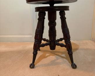 H31 - $75. Adjustable height carved piano stool. Measures 14.5" x 19"T.