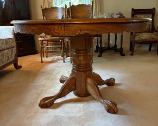 H42 - $150. Clawfoot pedestal dining table with 6 chairs and leaf. Table measures 48" x 30"T, Chairs measure 17.75" x 16" x 43"T, floor to seat 18"T. Two chairs have splitting in the seat as shown in photo.