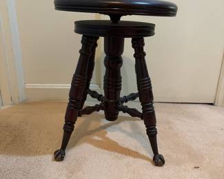 H31 - $75. Adjustable height carved piano stool. Measures 14.5" x 19"T.