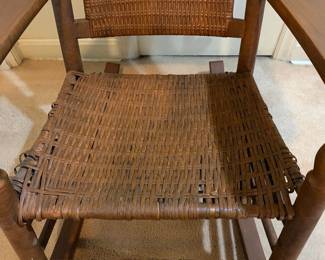 H29 - $40. Wood rocking chair with woven seat and back. Measures 26.25" x 24" x 35"T. Some separation of seat weaving as shown in photo.