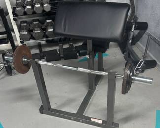 Commercial Preacher Curl Station with Olympic EZ-Curl Bar Setup  commercial-grade Preacher Curl Station. Outfitted with an extra-thick, ergonomically angled arm cradle to maximize bicep isolation while protecting the elbows. This premium package includes a balanced, high-tensile chrome Olympic EZ-Curl bar and a foundational set of Olympic iron plates with secure retention collars.