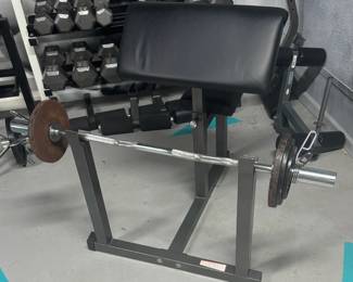 Commercial Preacher Curl Station with Olympic EZ-Curl Bar Setup commercial-grade Preacher Curl Station. Outfitted with an extra-thick, ergonomically angled arm cradle to maximize bicep isolation while protecting the elbows. This premium package includes a balanced, high-tensile chrome Olympic EZ-Curl bar and a foundational set of Olympic iron plates with secure retention collars.