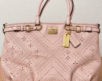 Coach Blush Pink Leather Tote Handbag ◆ Intricate woven-look geometric pattern ◆ Floral perforated detailing ◆ Double handles ◆ Gold-tone hardware ◆ Decorative buckles ◆ Coach logo and hanging tags