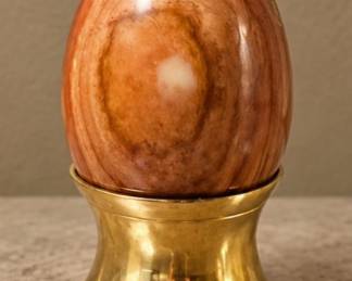 Brown Stone Egg — Polished warm brown stone with natural swirling patterns and brass stand.