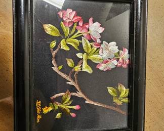 Framed Vietnamese Floral Embroidery — Pink and white blossoms with green foliage, intricately stitched on black fabric. Glossy black frame with gold “Viet Nam” lettering.
