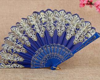 Ornate Blue Lace Folding Fan — Deep royal blue folding fan featuring intricate gold and ivory lace detailing, decorative blue ribs, and gold accents.