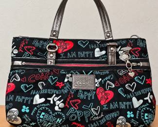 Coach Poppy Graffiti Print Tote Handbag ◆ Black fabric with red, turquoise, and white graphics ◆ Metallic double handles ◆ Silver-tone hardware ◆ Front zipper pocket ◆ Coach logo plaque and dangling charms