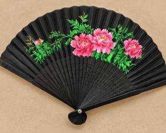 Black Floral Folding Fan — Black folding fan featuring bright pink flowers, green foliage, and decorative pierced ribs.