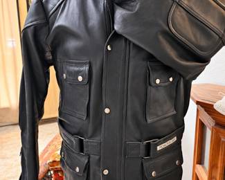 Roadgear Black Leather Motorcycle Jacket ◆ Heavy-duty leather ◆ Padded shoulders ◆ Multiple snap-closure pockets ◆ Zipper and snap front ◆ Adjustable waist straps ◆ High collar