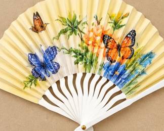 Floral & Butterfly Folding Fan — Pale yellow folding fan featuring colorful butterflies, flowers, and white ribs.