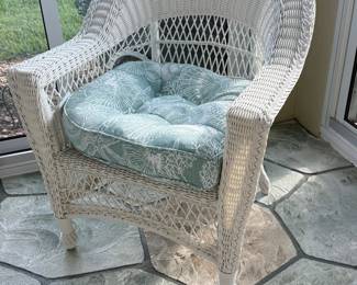 White wicker armchair with shell-print cushion