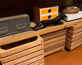Wooden crates on wheels, onyx panther figurine, industrial drawers
