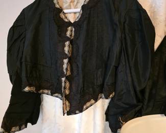 Victorian or Edwardian-style black silk or satin jacket/bodice featuring full or puffed sleeves,