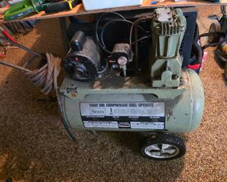 vintage Sears Air Compressor, typically featuring a twin-cylinder pump and a portable tank