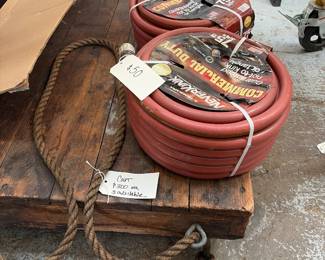 275 foot three-quarter wrench commercial Duty guaranteed not to link hoses sitting on top of a antique wooden cart.