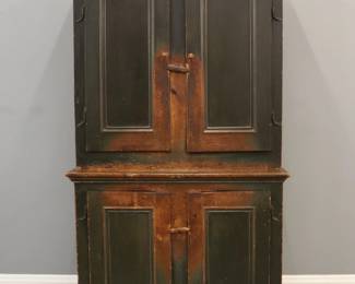 An early 19th century painted stepback cupboard.  Pine construction with the original green paint features two flat panel doors above two lower doors with rattail hinges on a base with cut out feet.  Wear and scratches to paint, replaced knobs.  49 x 18 x 83 1/2" high overall.  