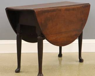 An 18th century American Queen Anne Period drop leaf side table.  Dovetailed Cherry construction features a rounded edge top, on a gate-leg base with tall turned legs and raised pad feet.  Older finish with minor wear, some shrinkage, top has a small square repair and lacks one wooden peg.  42 x 15 (46 1/2" open) x 27 2/4" high overall.  