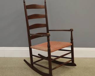 A late 19th to early 20th century Shaker No. 5 rocking chair.  Features a ladder back chair with tape seat.  Impressed "5" at top slat.  Replaced tape seat, varnish over original color on base and bottom of legs, with some wear and light scratches.  39 1/4"high. 