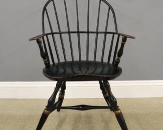 An early 19th century American sack-back Windsor armchair.  Mixed wood construction with Pine seat, features a bow back with turned spindles and shaped arm rail, over a shaped plank seat with turned splayed legs and stretcher base.  Older re-painted finish with some wear, rod spindles added for support, minor damage and repairs.  40 1/2" high.  
