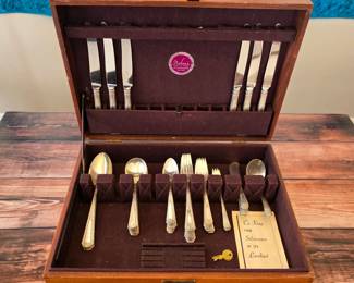 Towle Louis XIV sterling silver flatware with sterling-handled knives, displayed in a wooden flatware chest.