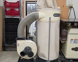 Shop Fox woodworking dust collector with collection bag and flexible hose.