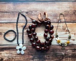 Statement necklaces with floral accents, colorful beads, chunky natural textures, and playful button details. Jewelry with plenty of personality.